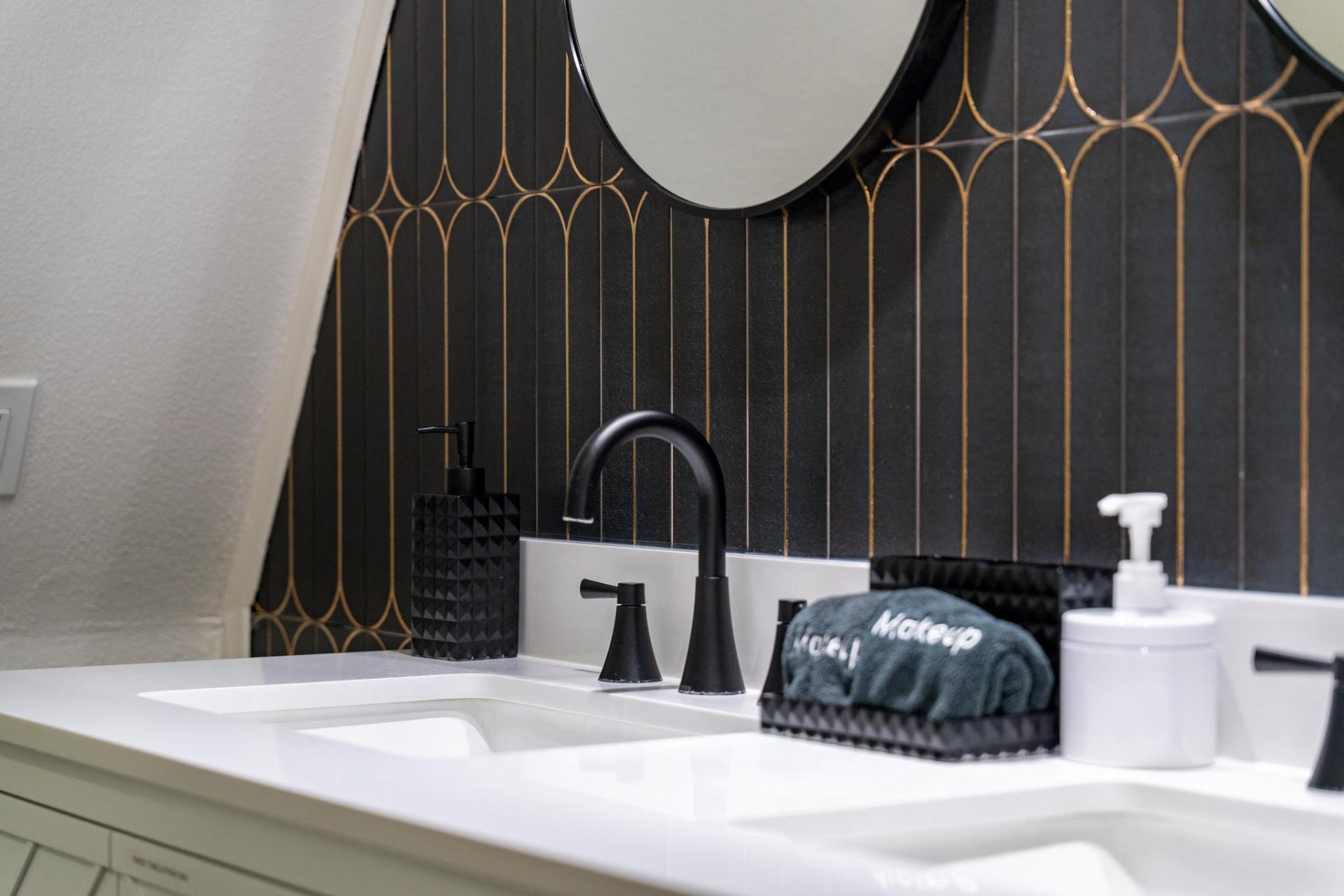 Detail of art deco navy tile and matte black fixtures