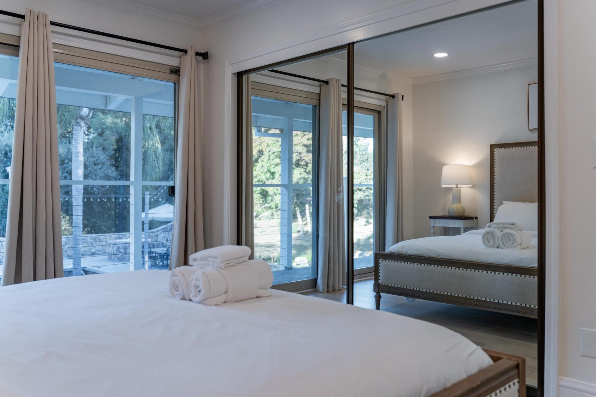 Guest bedroom with mirrored closets and balcony