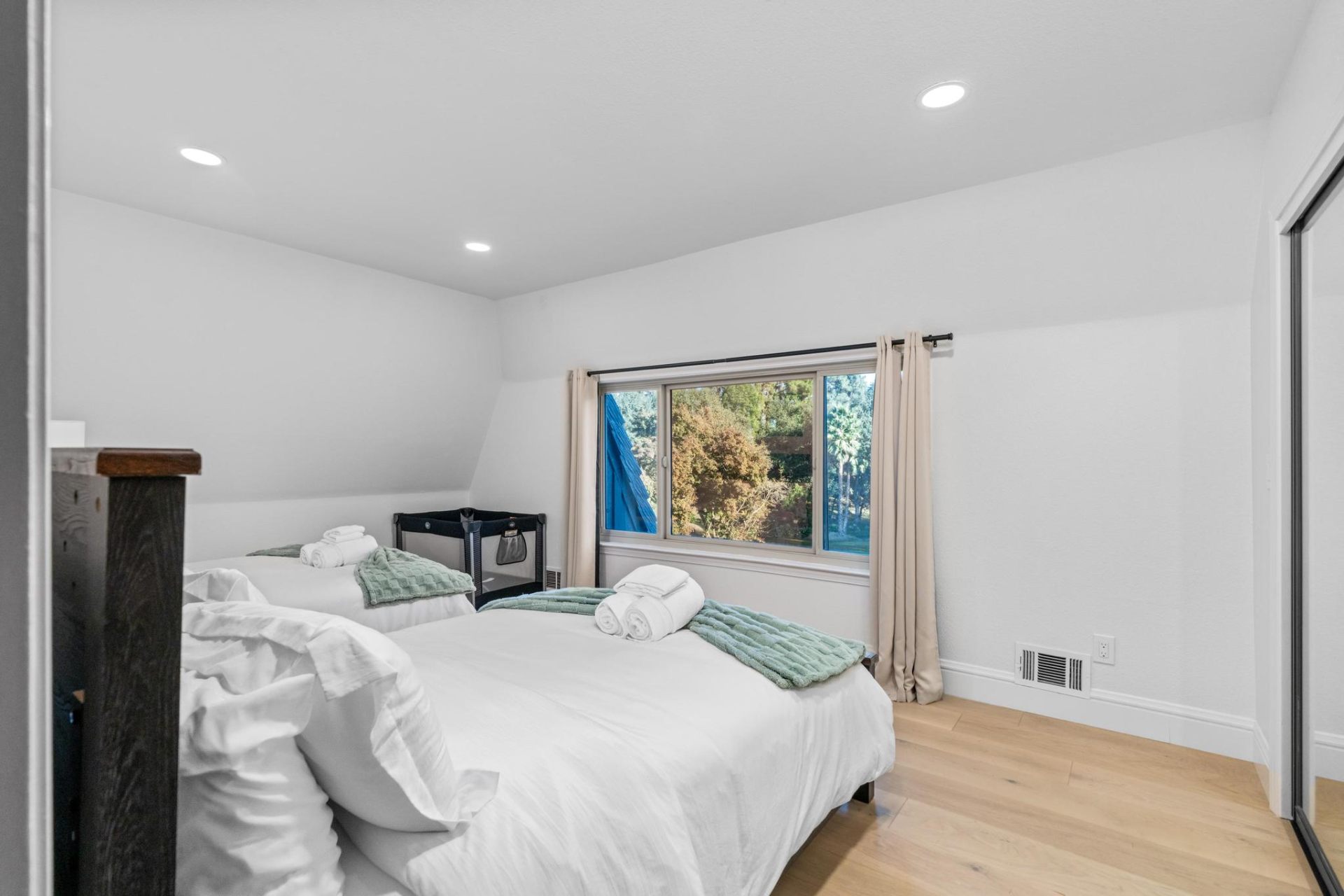Bright twin bedroom with treetop window views