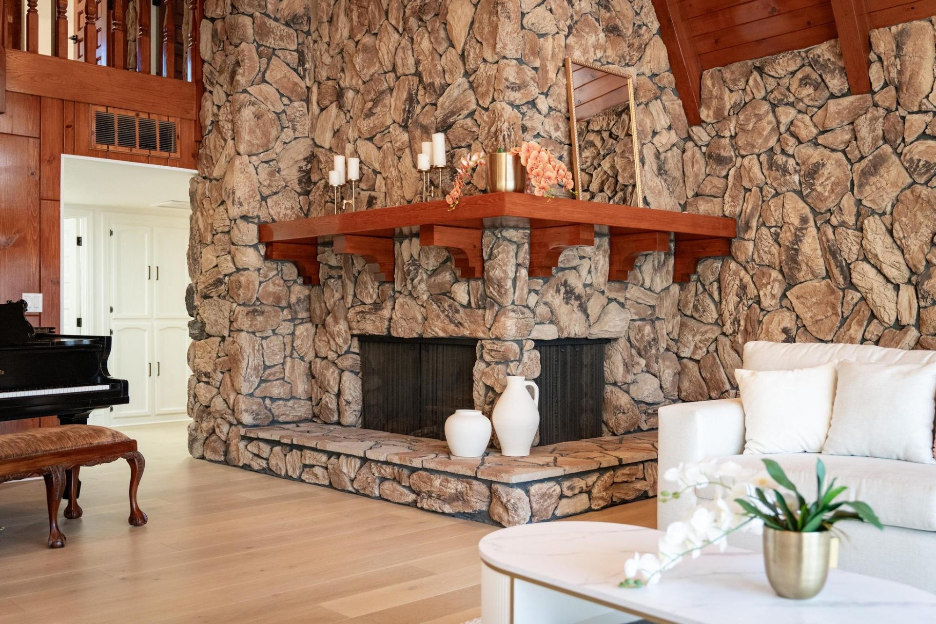 Towering natural stone fireplace with cherry-wood mantel
