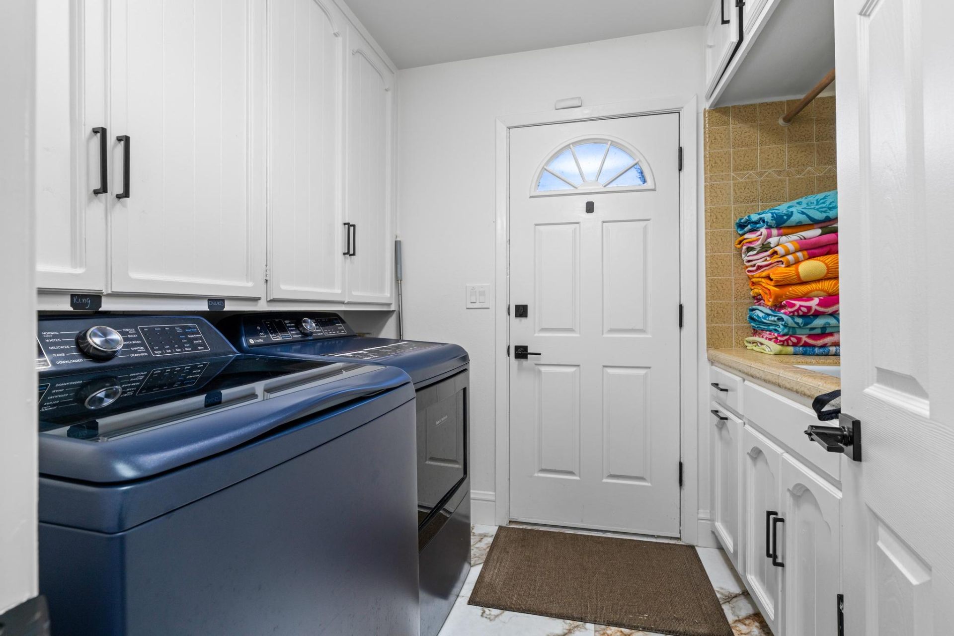 Laundry room with stacked beach towels and washer/dryer