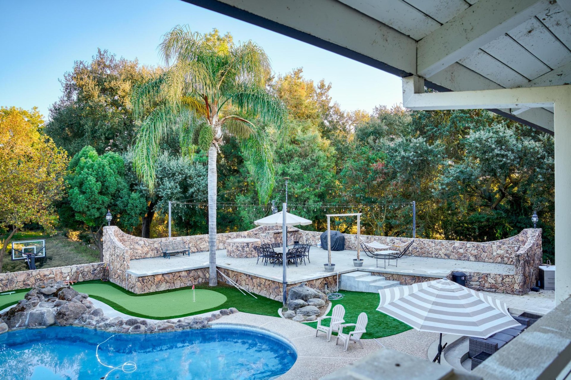 Upper stone patio with palm and dining