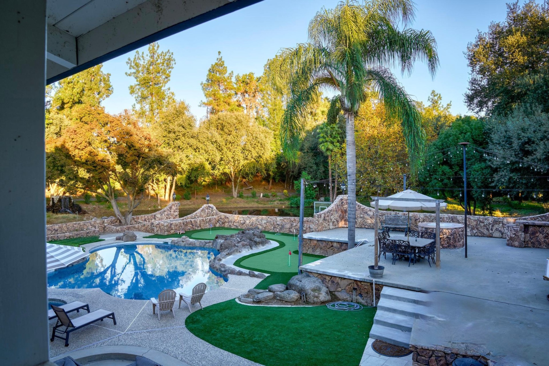 Pool, jacuzzi, and putting green at golden hour