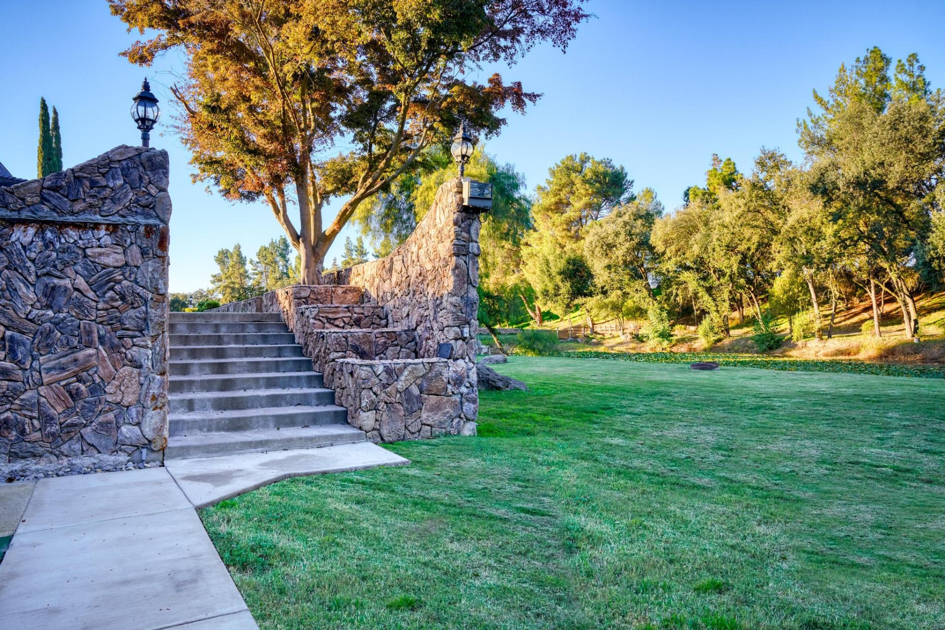 Grand stone staircase descending to the lawn and pond